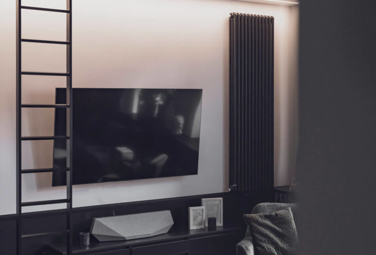 klimat wnętrza, przytulny salon, drewniana podłoga, obraz, plakat na ścianie, styl industrialny, biblioteka w domu