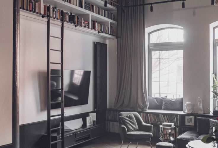 klimat wnętrza, przytulny salon, drewniana podłoga, obraz, plakat na ścianie, styl industrialny, biblioteka w domu