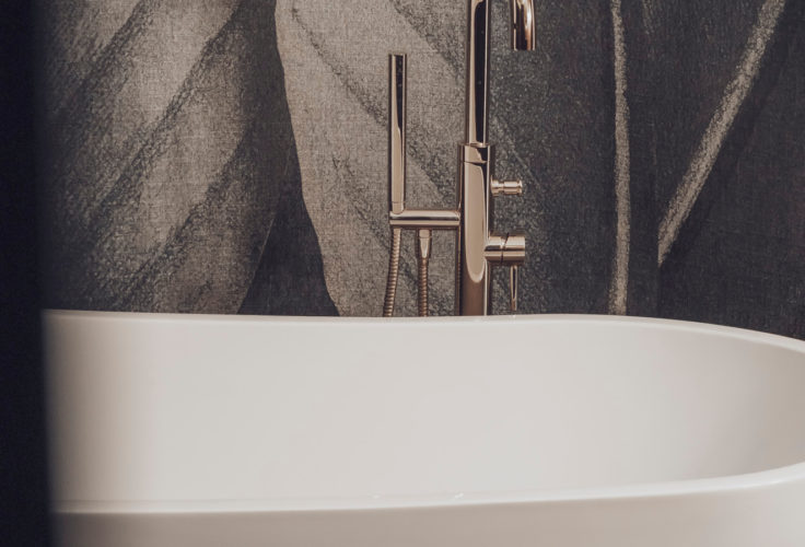 tapeta w liście, czarna szafka umywalkowa, czarna umywalka, ciemna łazienka, złote dodatki, luksusowa łazienka